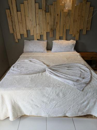 a large white bed with a wooden headboard at Almasi lounge in Arusha