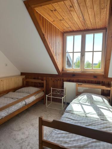a attic room with two beds and a window at agroOBERIBA in Płatkownica