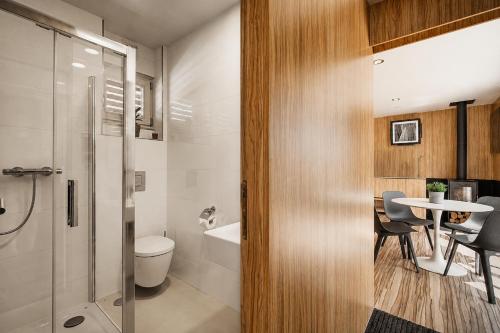 a bathroom with a shower and a toilet and a table at Nedomek by Homester in Neslovice