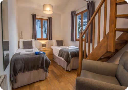 a room with two beds and a stair case at Chalet Broski - Spacious Chalet with Hot Tub, Sauna & BBQ in Planvillard