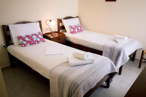 two twin beds in a room with a table at Aphrodite Residence - Seafront apartment, Melissi in Melíssion