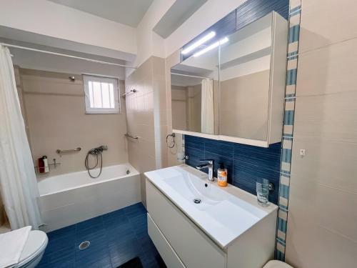 a bathroom with a sink and a tub and a toilet at Aphrodite Residence - Seafront apartment, Melissi in Melíssion