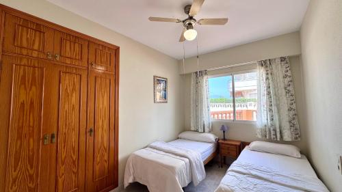 a bedroom with two beds and a ceiling fan at Talima Vyb Dénia in Denia