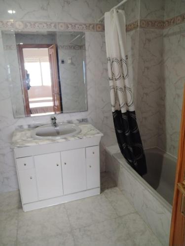 a bathroom with a sink and a mirror and a tub at Talima Vyb Dénia in Denia