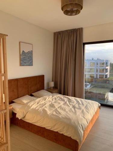 a bedroom with a bed and a large window at SolMarina Apartment for Rent in Wiślinka