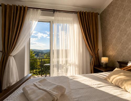 a bedroom with a bed and a large window at Hotel Three Korony in Skhidnitsa