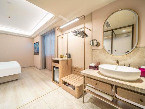 a bathroom with a sink and a large mirror at Mercure Shanghai Lujiazui in Shanghai