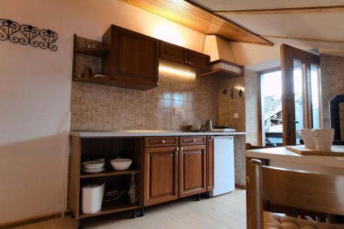 a kitchen with wooden cabinets and a white refrigerator at Casa dello Scoiattolo in Bieno