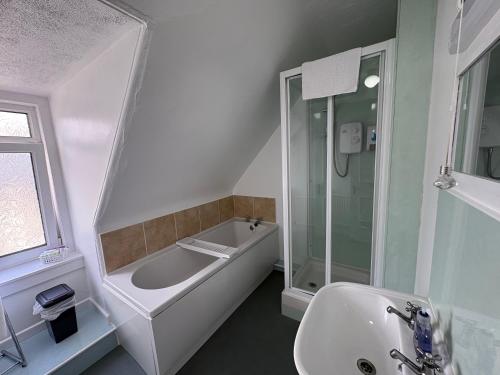 a bathroom with a shower and a tub and a sink at Glendale Guesthouse in Oban
