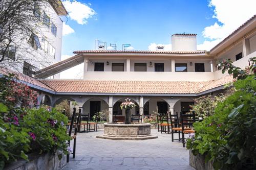 a courtyard with a fountain in front of a building at Hotel Jose Antonio Cusco in Cusco