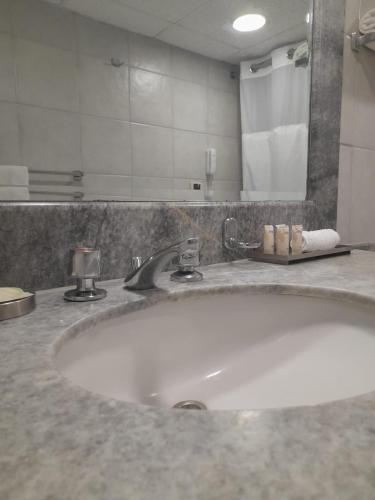 a bathroom with a sink and a large mirror at Suites del Bosque Hotel in Lima