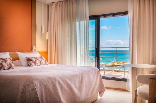 a bedroom with a bed and a view of the ocean at Atlantic Hôtel & Spa in Les Sables-d'Olonne