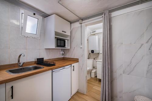 a small kitchen with a sink and a toilet at Vista del Mar Guest House in Albufeira