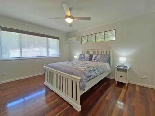 a bedroom with a bed and a ceiling fan at Brownies on Birch in Amity Point