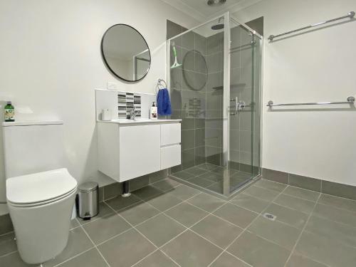 a bathroom with a shower and a toilet and a sink at Brownies on Birch in Amity Point
