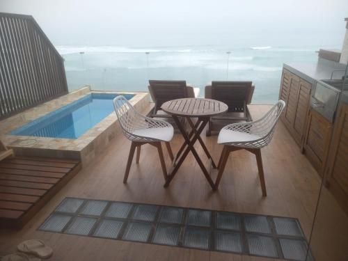 a patio with a table and chairs and a pool at Oceanview 2BR with Terrace in Punta Hermosa in Punta Hermosa