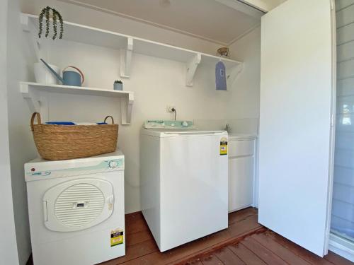 a laundry room with a washing machine and a washer at Sandy Shores in Amity Point
