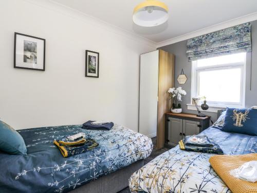 a bedroom with two beds and a window at Kilmartin View in Lochgilphead