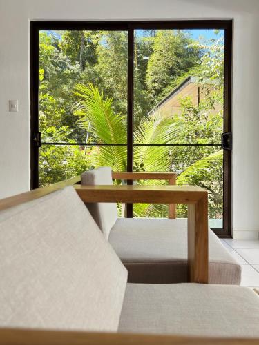 a table and chairs in front of a large window at Encantador Loft con Piscina 1 BDR in Santa Teresa Beach