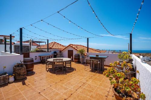 a patio with tables and chairs on a balcony with the ocean at Villa Coral 3 BR 3BA with pool in Primo Tapia