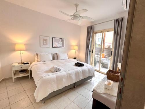 a bedroom with a large white bed and a window at Olive Apartment in Tala