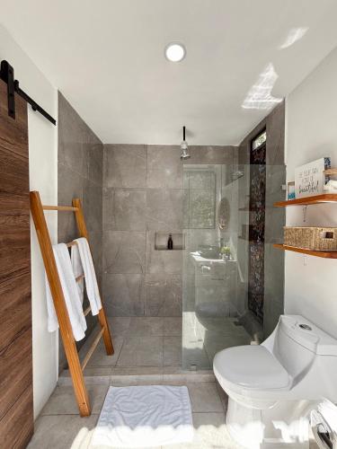a bathroom with a toilet and a shower at Encantador Loft con Piscina 1 BDR in Santa Teresa Beach