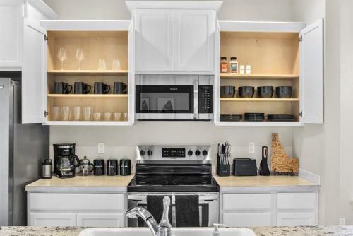 a kitchen with white cabinets and a stove at Highland Haven by Settler's Park in Meridian