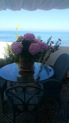 a table with a vase of purple flowers on it at Dar Moussa Assilah in Asilah
