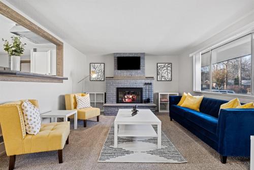 a living room with a blue couch and a fireplace at Poolside Paradise with Hot Tub in Boise