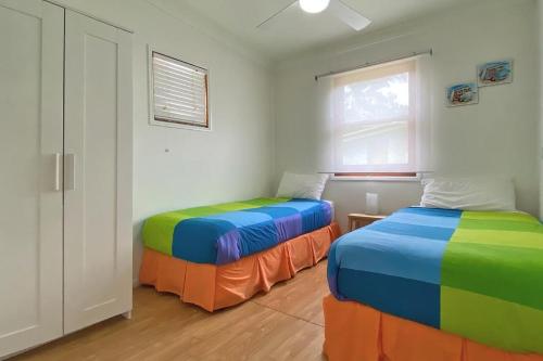 a room with two beds with colorful sheets at Saltys Amity Point in Amity Point