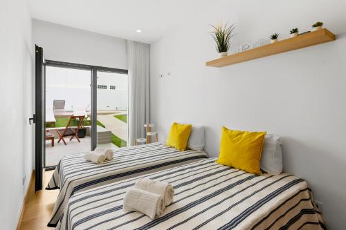 a bedroom with two beds with yellow pillows at JB RiaMar l by Meditrust in Alvor