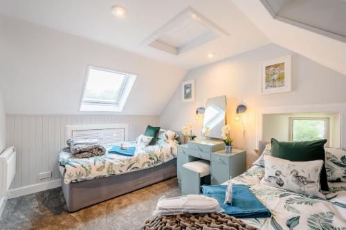 a bedroom with two beds and a mirror at Smithy House in Lochgilphead