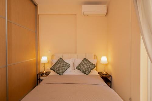 a bedroom with a large bed with two lamps at Captain's Corner in Markopoulo