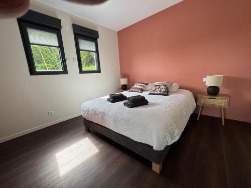 a bedroom with a bed and two windows at Brin d'Air Lodge in Montcornet