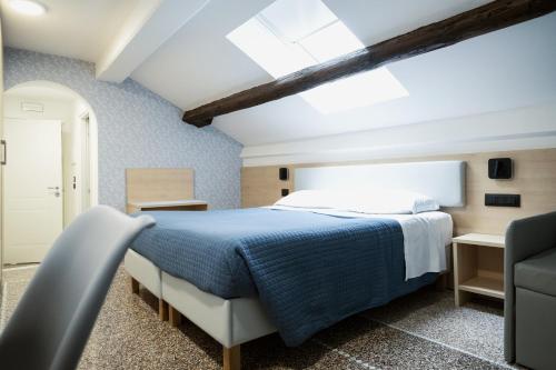a bedroom with a bed with a blue blanket at Hotel Caffaro in Genoa