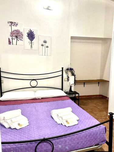 a bedroom with a purple bed with towels on it at Le Saliscalette in Norcia