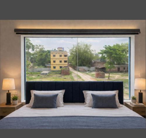 a bedroom with a large window with a large bed at Chouhan Resort in Katihār