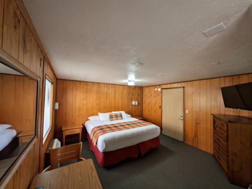 a bedroom with a bed and a desk and a television at The Orca Inn in Friday Harbor