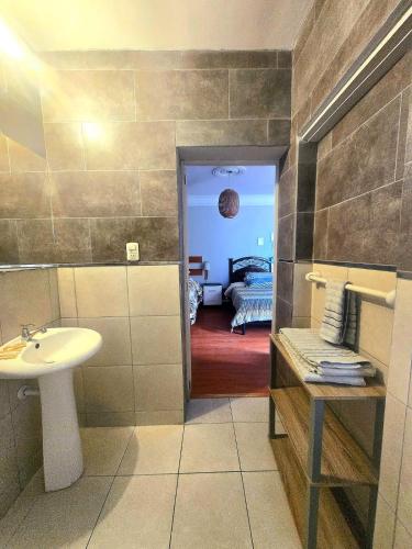 a bathroom with a sink and a toilet and a bedroom at Colonial San Lazaro Apart Hotel in Arequipa