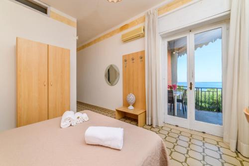 a bedroom with a bed with a view of the ocean at Hotel Royal in Villammare