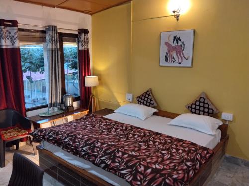 a bedroom with a bed and a window at The Explorer's Den in Munsyari