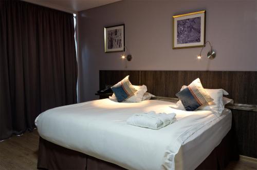 uma grande cama branca com duas almofadas em Smart Hotel Bishkek em Bishkek