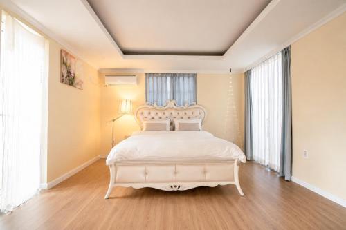 a bedroom with a white bed with a white headboard at Jeju Semo, Byeol in Seogwipo