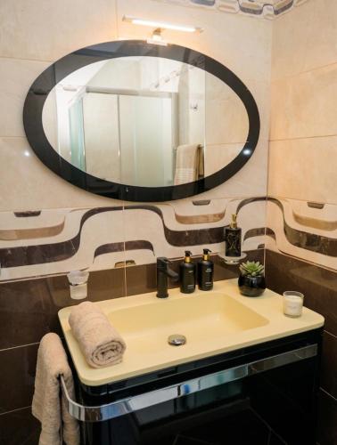 a bathroom with a sink and a large mirror at Elena Seaview Apartment in Vlorë