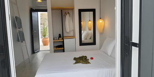 a bedroom with a white bed with a red ball on it at Maria's Private Space - Mykonos in Ano Mera
