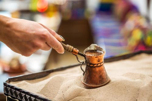 a person is holding a pipe in the sand at Complex Vazrozhdentsi in Tryavna