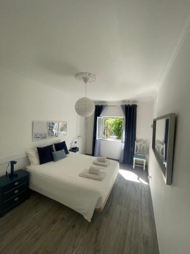 a bedroom with a large white bed and a television at Casa La Isla in Sagres