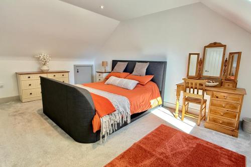 a bedroom with a bed and a dresser and a mirror at The Hayloft in Ringwood