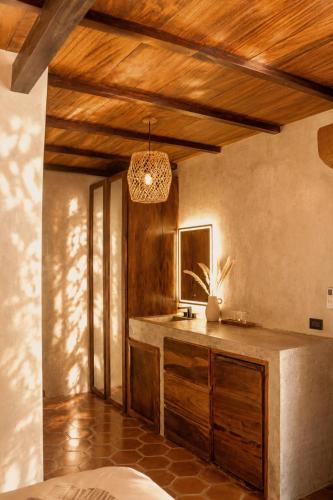 a kitchen with a sink and a wooden ceiling at Casona Tunan in Santa María Mizata