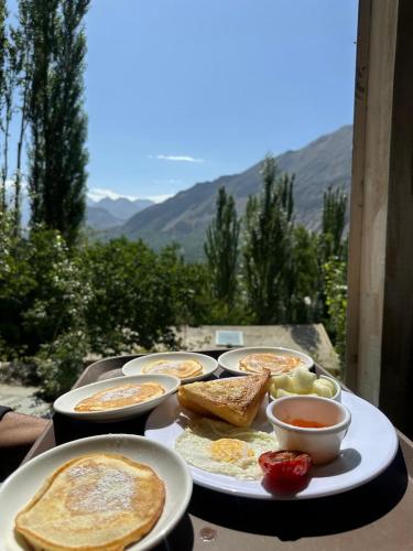 a table with plates of breakfast food on it at Trivor resort in Hunza Valley